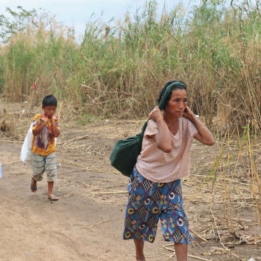 Displaced people from Myanmar carry donated lunch boxes to their tents along the Thai side of the Moei River in Mae Sot