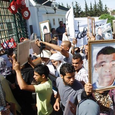People hold up pictures of relatives who died in protests during the January 2011 revolution, at a demonstration outside a military court in Tunis June 26, 2012.