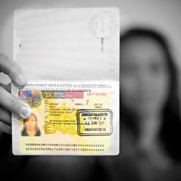 A domestic worker holds up her UK Overseas Domestic Worker visa. Following changes to the immigration rules in April 2012, workers entering the UK on this visa are not permitted to change employer, making them more vulnerable to abuse.