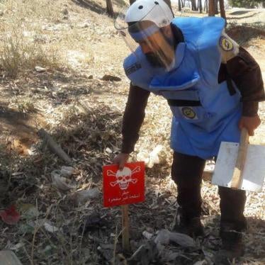 Un technicien faisant partie d’une équipe de « Casques bleus » de la Défense civile syrienne (Syria Civil Defense) pose un écriteau sur le site d’une sous-munition non explosée dans le gouvernorat d'Idlib, en vue d’une future opération de déminage.