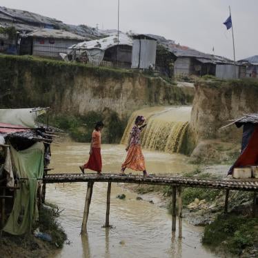 Rohingya refugee girls cross a makeshift bamboo bridge at Kutupalong refugee camp, where they have been living amid uncertainty over their future after they fled Myanmar to escape violence a year ago, in Bangladesh, Tuesday, Aug. 28, 2018.