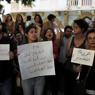 A group of Lebanese activists chant slogans as they hold Arabic placards that read: "Freedom of expression," right, and "With Mashrou' Leila against the suppression of freedoms. 