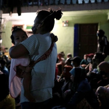 An undocumented migrant holds her daughter while being detained during an immigration raid