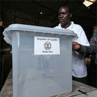 Les membres de la Commission électorale en Ouganda examinent l'urne de vote transparente essayée à Kampala. © Reuters 2006