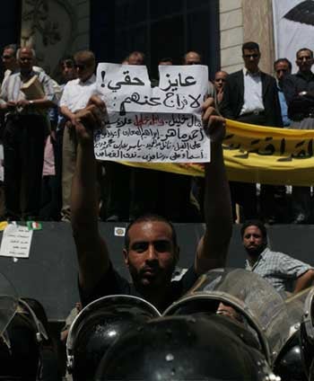 Muhammad Al-Sharqawi protests in front of the Press Syndicate in Cairo, May 25, 2006, about an hour before his arrest. The sign reads 