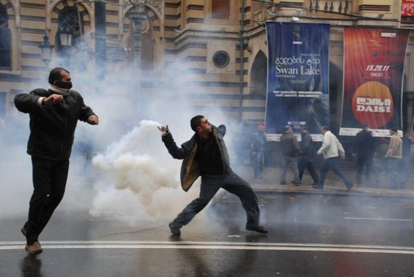 A protestor hurls a tear gas canister back at police in downtown Tbilisi. 