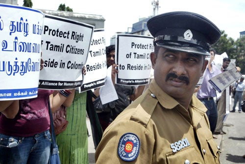 A Sri Lankan police officer in Colombo stands guard at a protest against the eviction of Tamils from the capital on June 8, 2007.  The night before authorities forcibly transported 376 Tamils from the city to the predominantly Tamil town of Vavuniya. © 2007 AP/Eranga Jayawardena