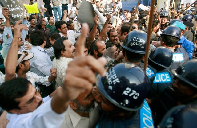 Police in riot gear confront journalists protesting media curbs 

and emergency rule in Karachi on November 20, 2007. Over a hundred 

journalists gave themselves up for arrest after clashing with police 

outside the press club in Karachi. 
© 2007 Reuters
