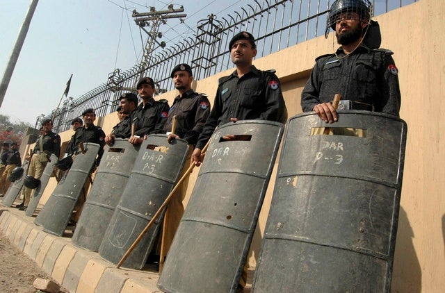 Police officers in full riot gear stand guard outside the Peshawar 

High Court buildings, on November 5, 2007. 
© 2007 Reuters

