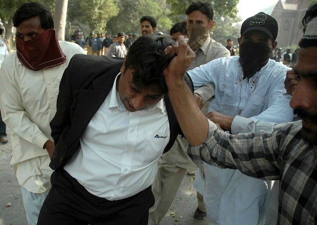 Plainclothes policemen arrest a lawyer outside provincial high 

court in Lahore on November 5, 2007. 
© 2007 Reuters

