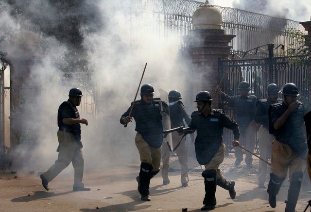 Police run to avoid teargas during clashes with lawyers at the main 

entrance of the provincial high court in Lahore on November 5, 2007. 
© 2007 Reuters

