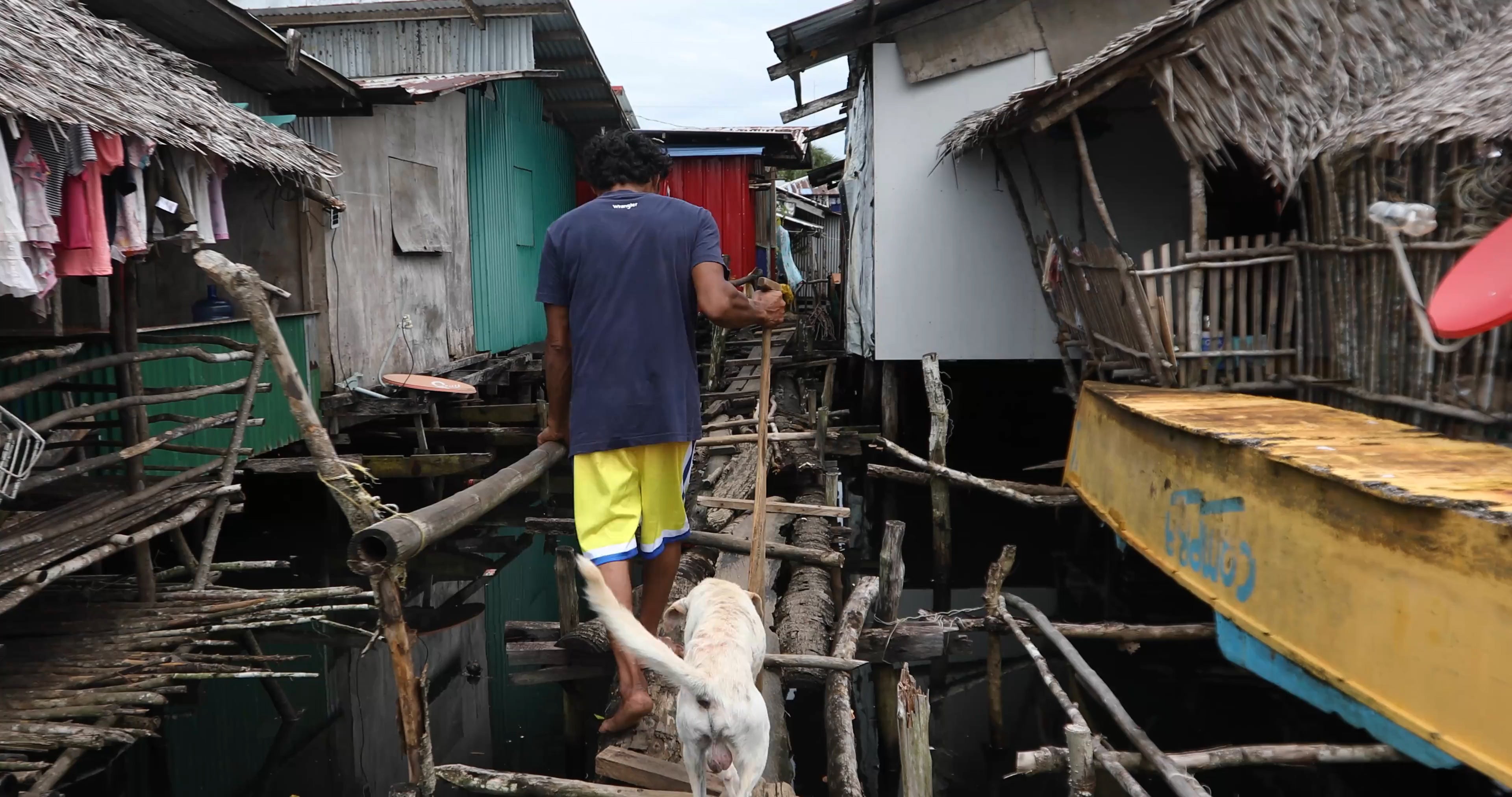 Hasael walking with his dog toward his boat in Del Carmen, Siargao, Philippines, 2025. (C) 2025 Camille Robiou du Pont/Human Rights Watch  