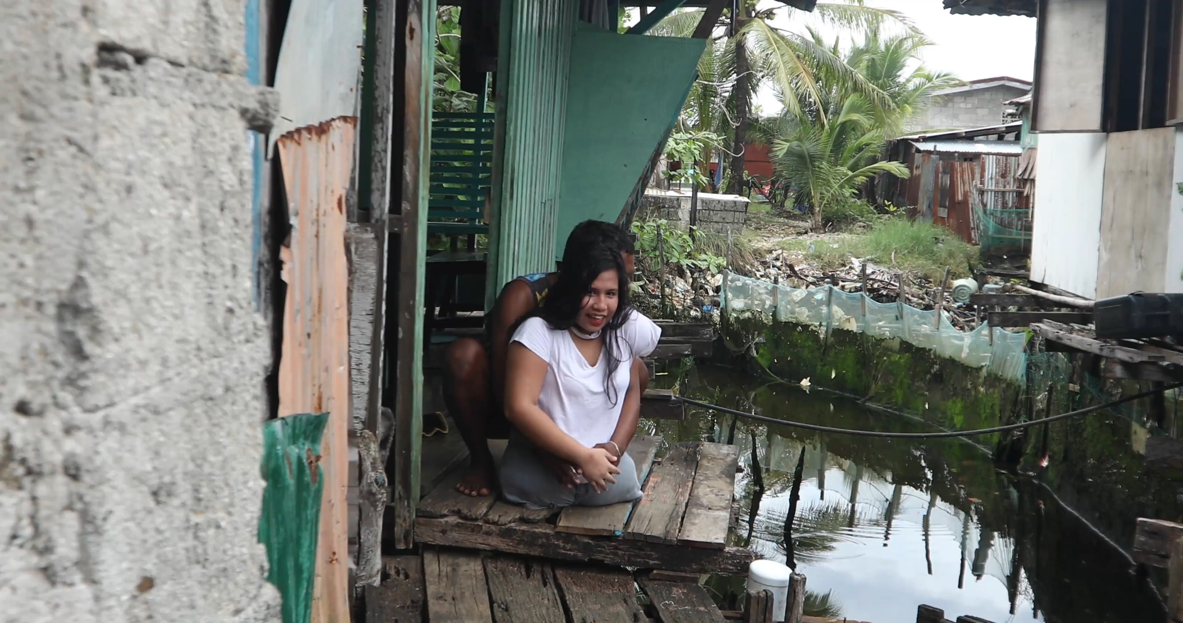 Johanna’s relative carrying her from their home to the street in Del Carmen, Siargao, Philippines, 2025. (C) 2025 Camille Robiou du Pont/Human Rights Watch  