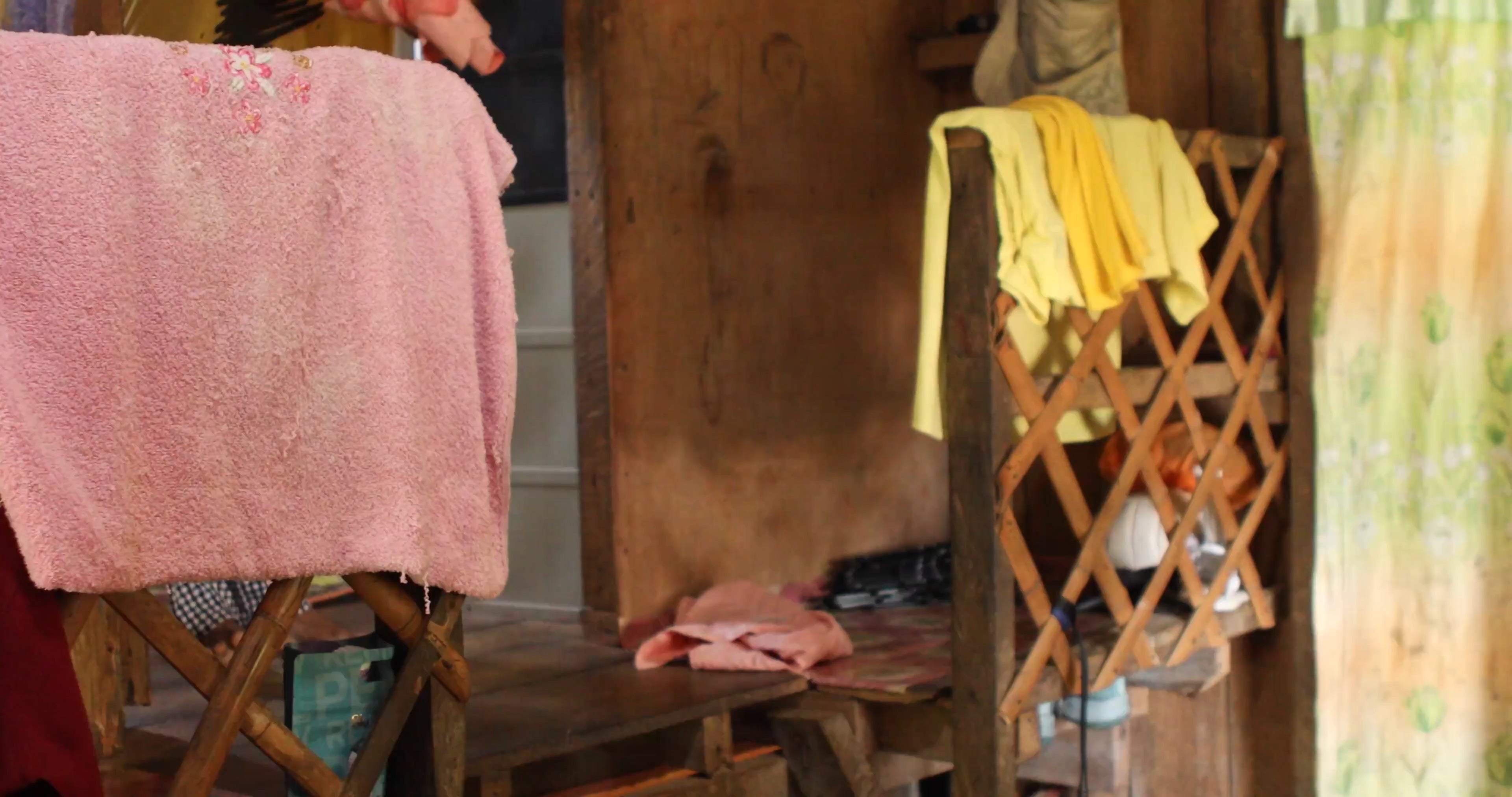 Zenaida is a polio survivor who finds even short walks painful, such as moving down  stairs in her home in Siargao, Philippines, 2025. (C) 2025 Camille Robiou du Pont/Human Rights Watch 