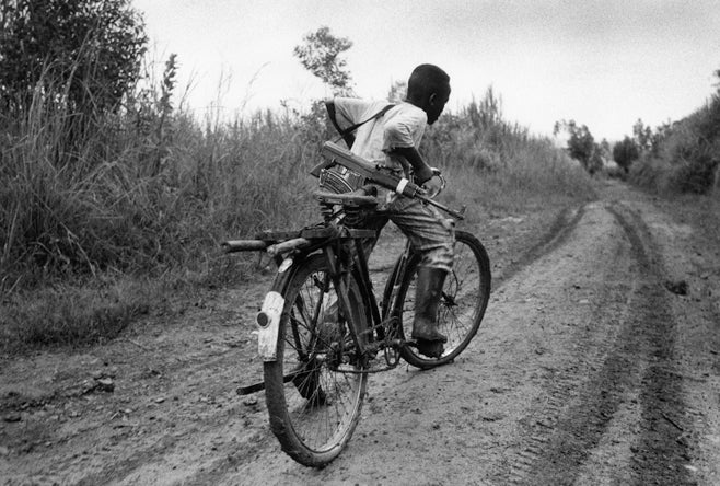 A child soldier rides back to his base in Ituri Province. Children are routinely recruited as soldiers in Congo by all sides.