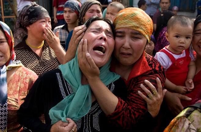 一群维吾尔族妇女泣诉家中男性因参加2009年7月5－7日在乌鲁木齐的抗议活动后被中国当局抓走，中国，2009年7月7日。