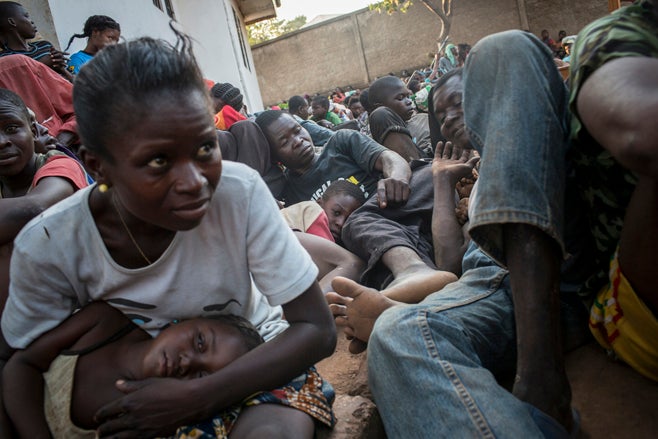 Une habitante de Bossangoa, dans l'ouest de la République centrafricaine, fuit avec d'autres résidents lors d’une attaque par des forces anti-balaka contre des combattants ex-Séléka le 5 décembre 2013. La Force multinationale de l'Afrique centrale (FOMAC)