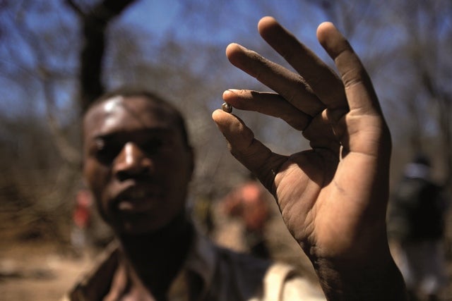 Un mineur tenant un diamant provenant des mines du Marange au Zimbabwe, une ressource financière stratégique pour le gouvernement. Pour contrôler les mines, la police et l'armée font souvent usage de la violence physique, voire mortelle.