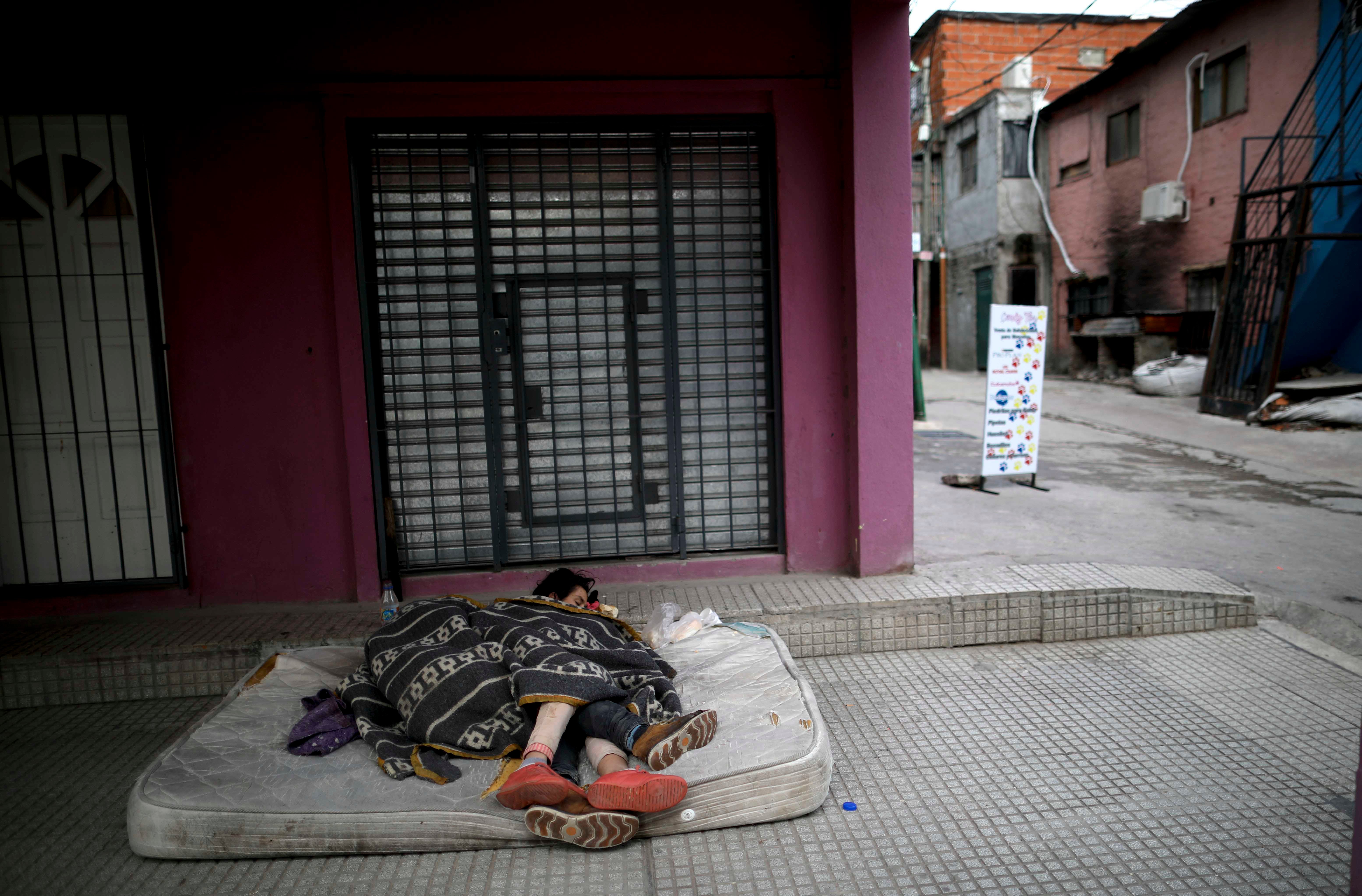 Homeless women sleep outside on a mattress in the "Villa 31" neighborhood during a government-ordered lockdown to curb the spread of the new coronavirus in Buenos Aires, Argentina, Wednesday, May 6, 2020. 