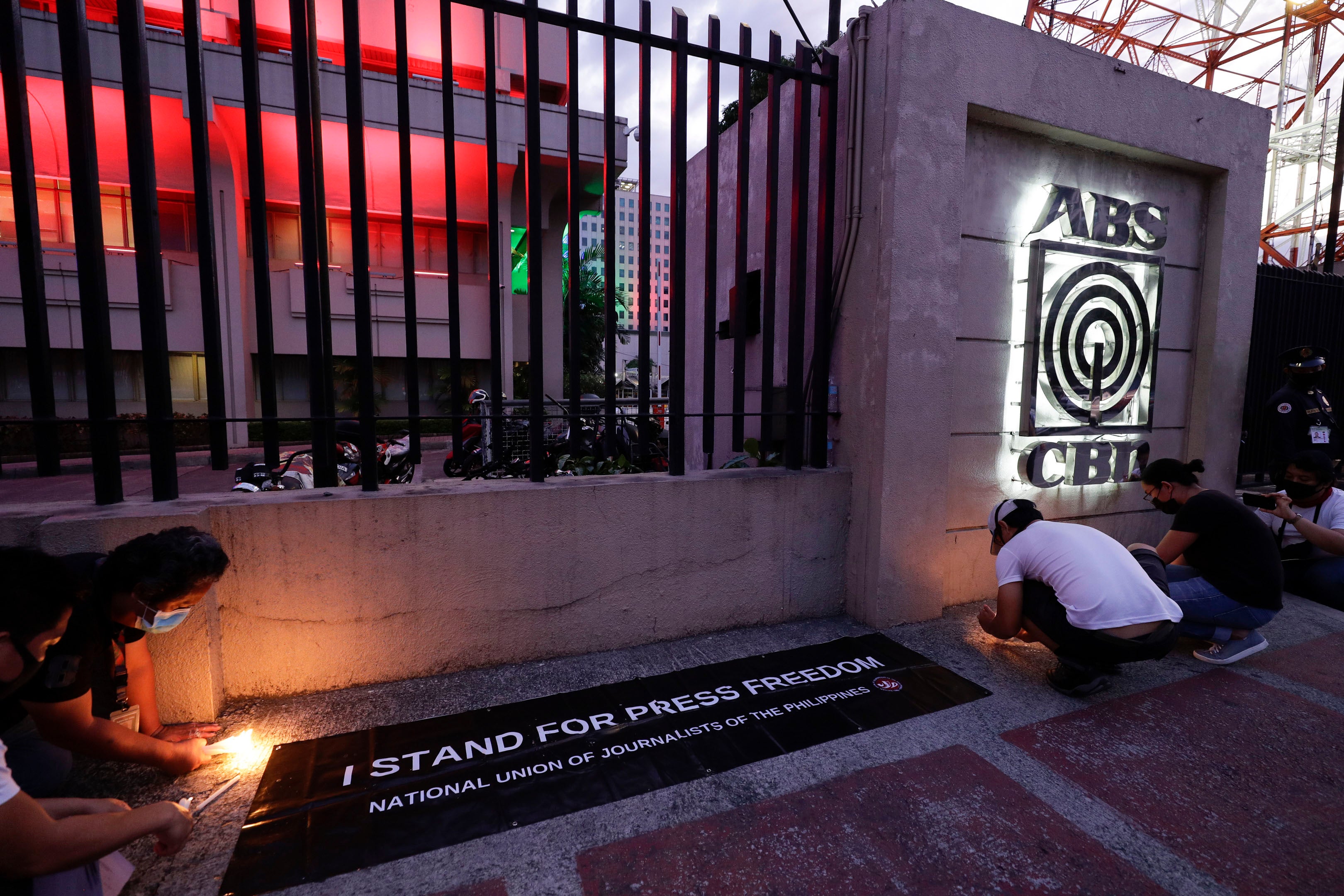 Employees light candles outside the headquarters of broadcast network ABS-CBN corp. on May 5, 2020, after the network was ordered to halt operations after its congressional franchise expired, in Quezon city, Metro Manila, Philippines.