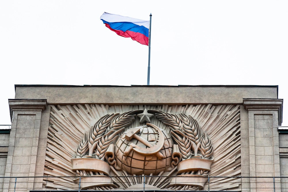 A Russian state flag waves on top of a hammer and sickle at the State Duma, lower parliament chamber, headquarters in Moscow, Russia