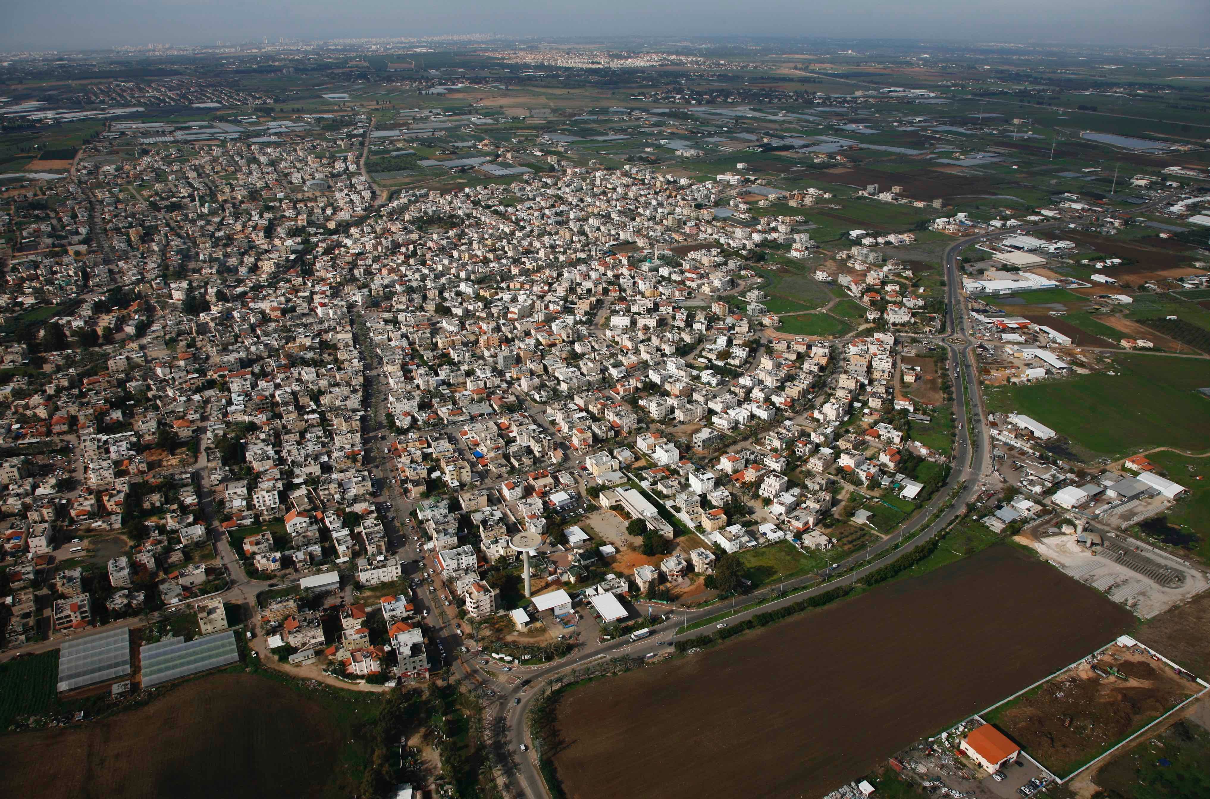 The dense residential core of Qalansawa, a Palestinian town in central Israel, with its lands zoned for agricultural use in the background. Aerial photography taken between 2011 and 2015.