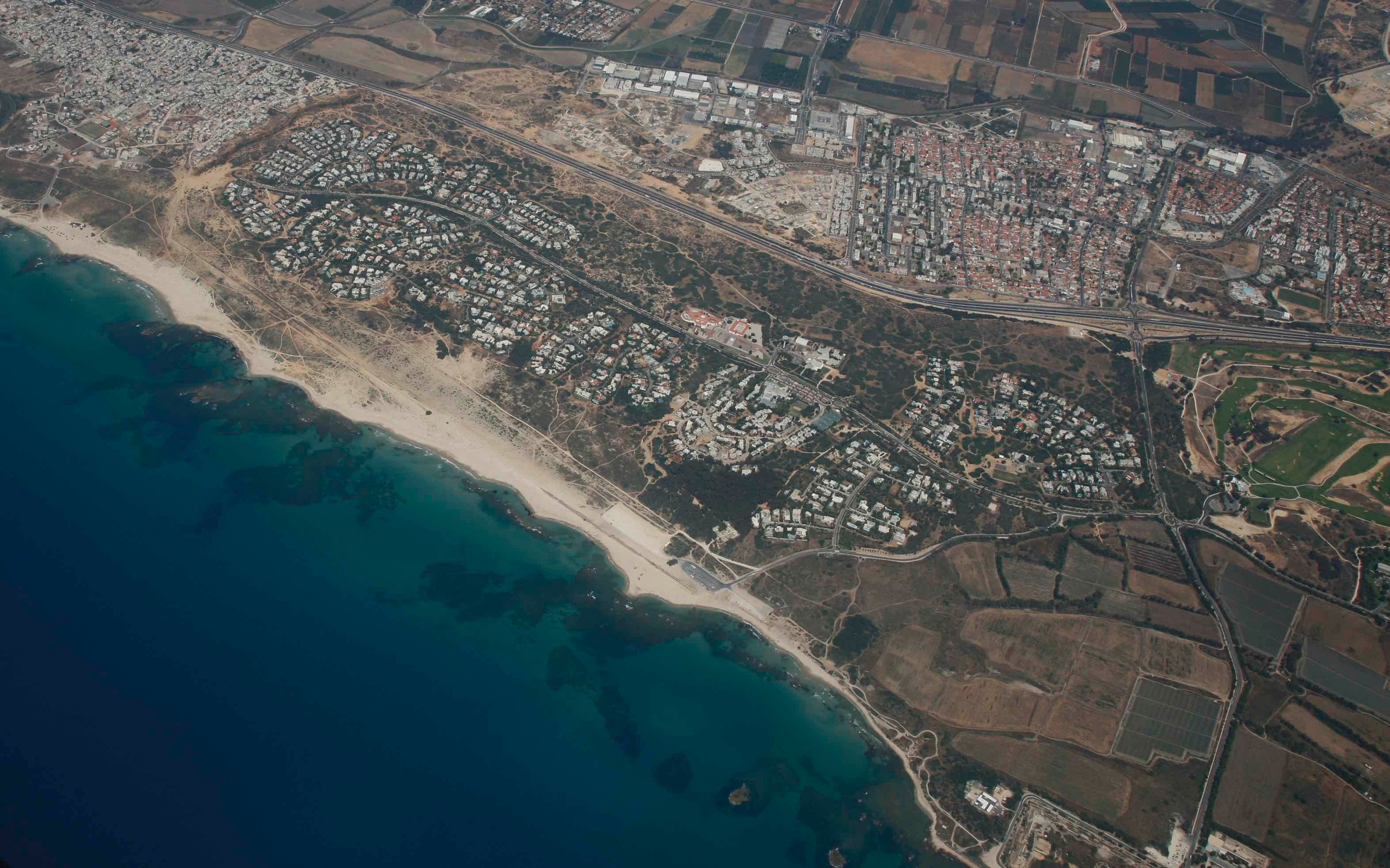 היישוב קיסריה, שרוב תושביו יהודים ואשר גובל בג'סר א-זרקא מצפון ובעיר אור עקיבא, שגם רוב תושביה יהודים, ממזרח. תצלום אוויר שצולם בין השנים 2015-2011.