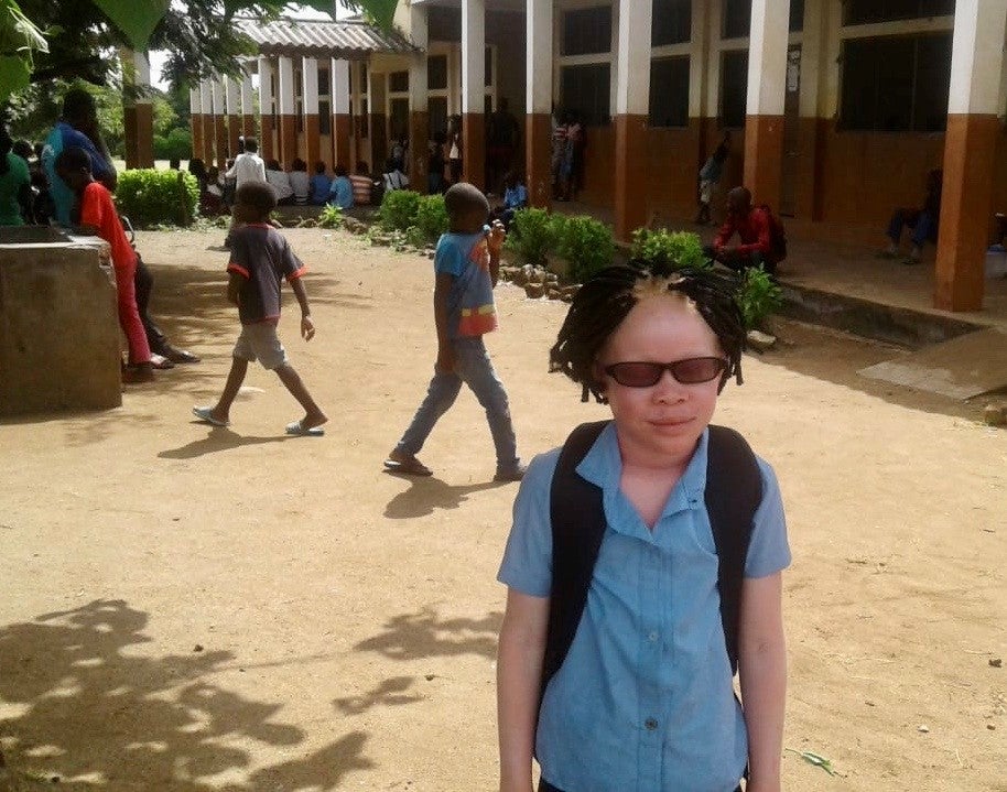 Josina usando seus novos óculos apropriados fora da sala de aula no distrito de Chiuta, na província de Tete, em Moçambique. Desde obter os óculos, Josina tem apresentado um melhor desempenho acadêmico, embora as escolas estão fechadas por causa da pandemia do Covid-19 no momento.