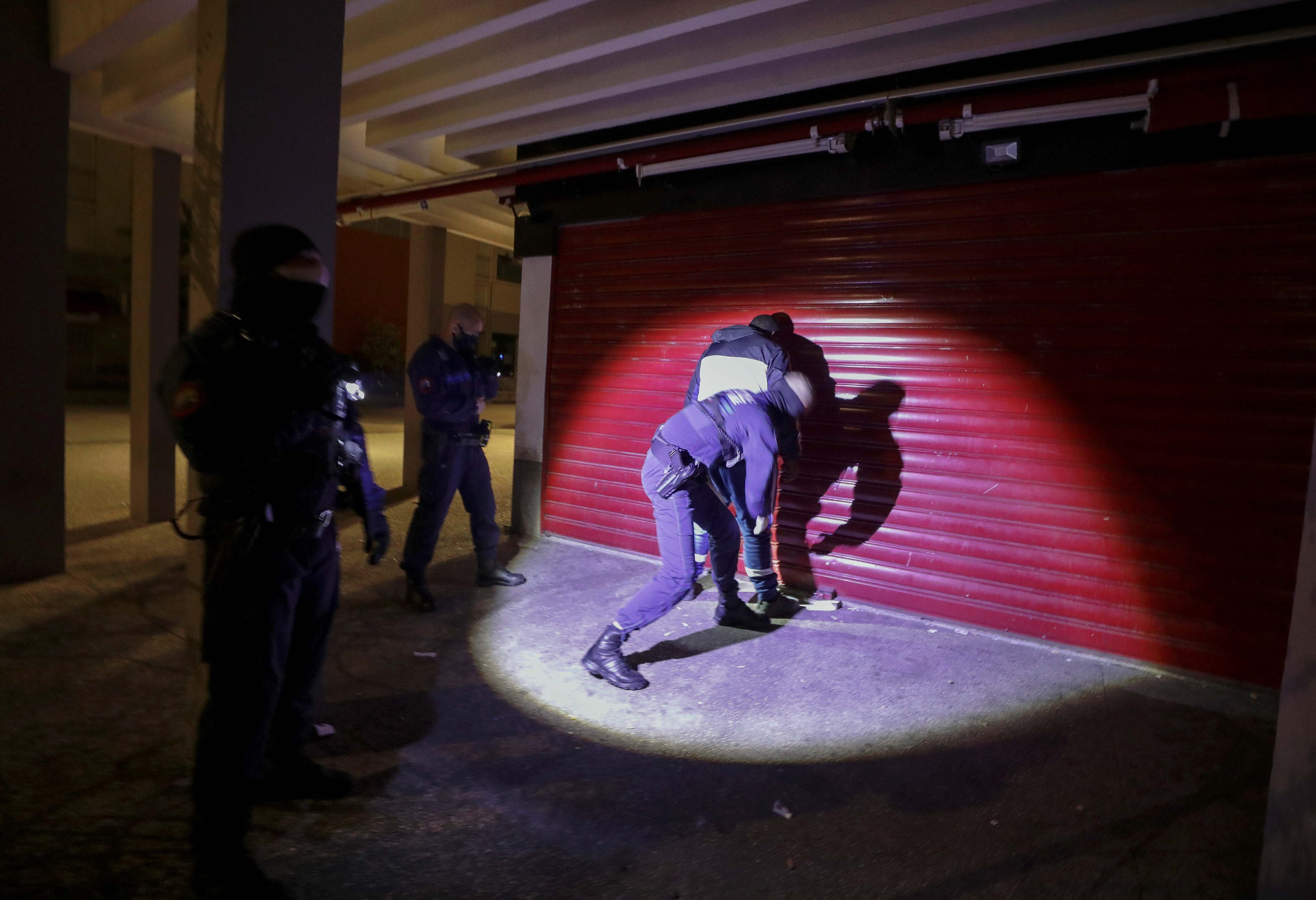 Police search a man at night