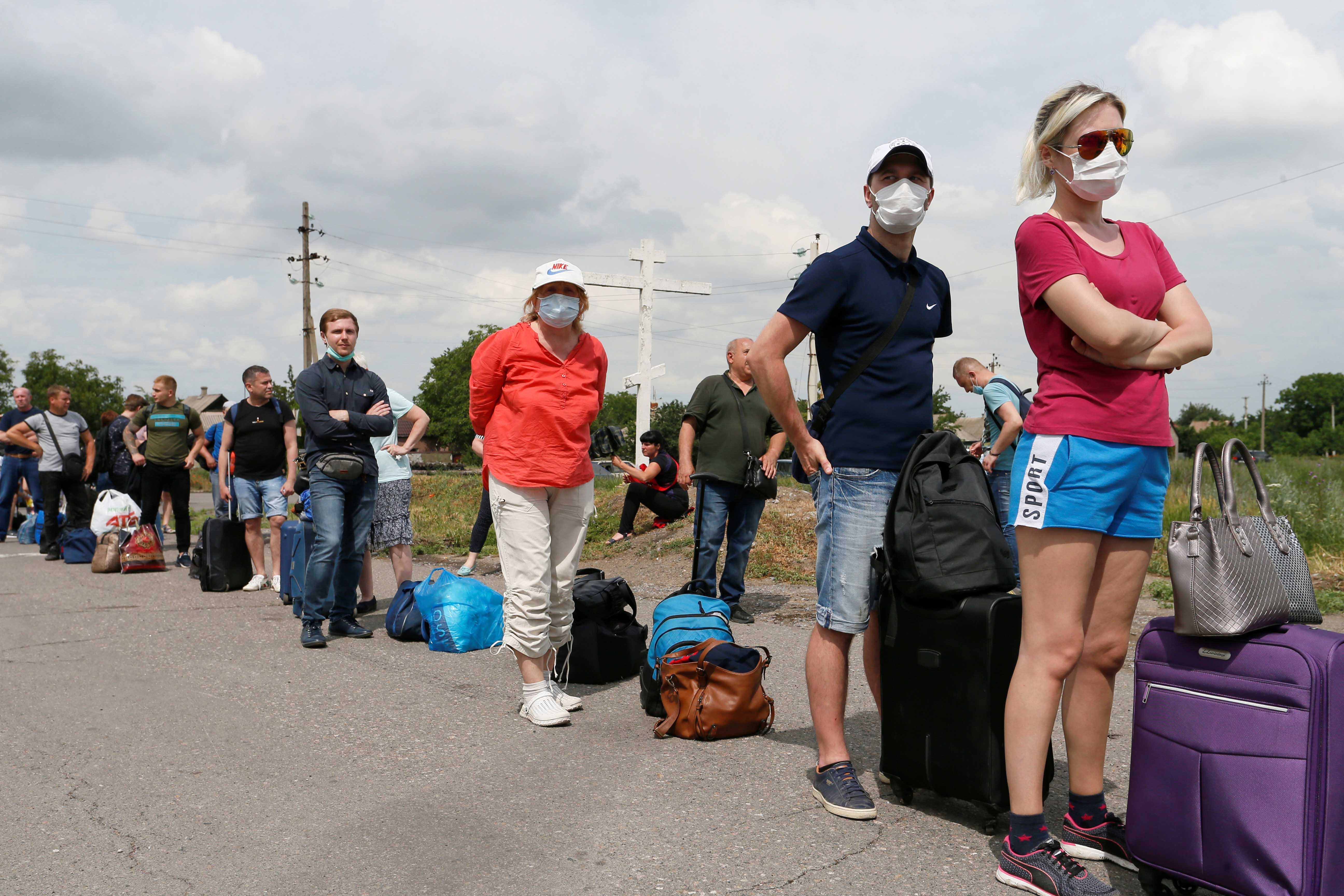People queue before leaving the territory of the self-proclaimed Donetsk People's Republic and crossing a separation line with Ukraine at a checkpoint, which was temporary closed due to the Covid-19 outbreak and then reopened, in Donetsk Region, Ukraine. June 22, 2020.