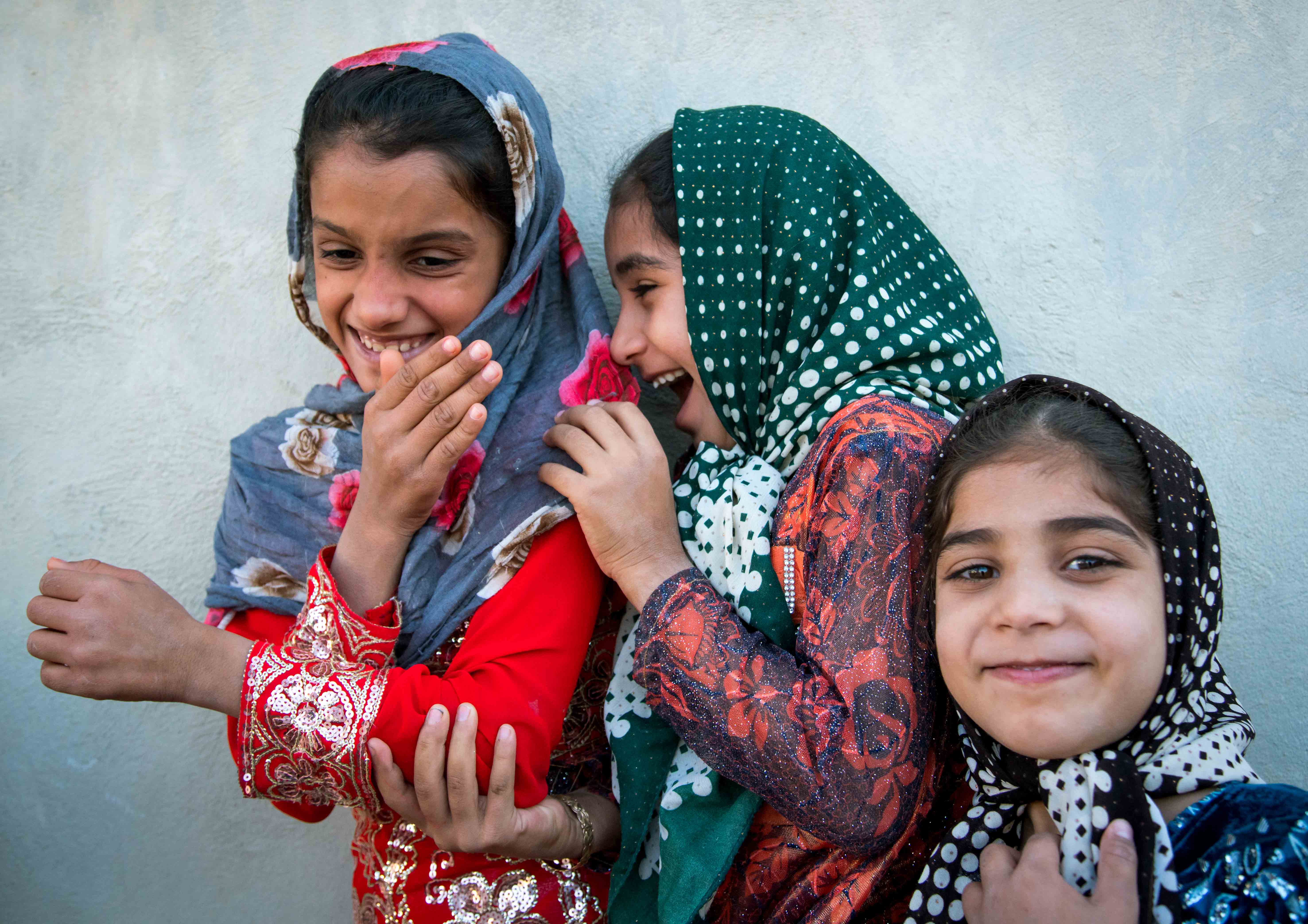 فتيات صغيرات يضحكن في الشارع في سلخ، إيران.