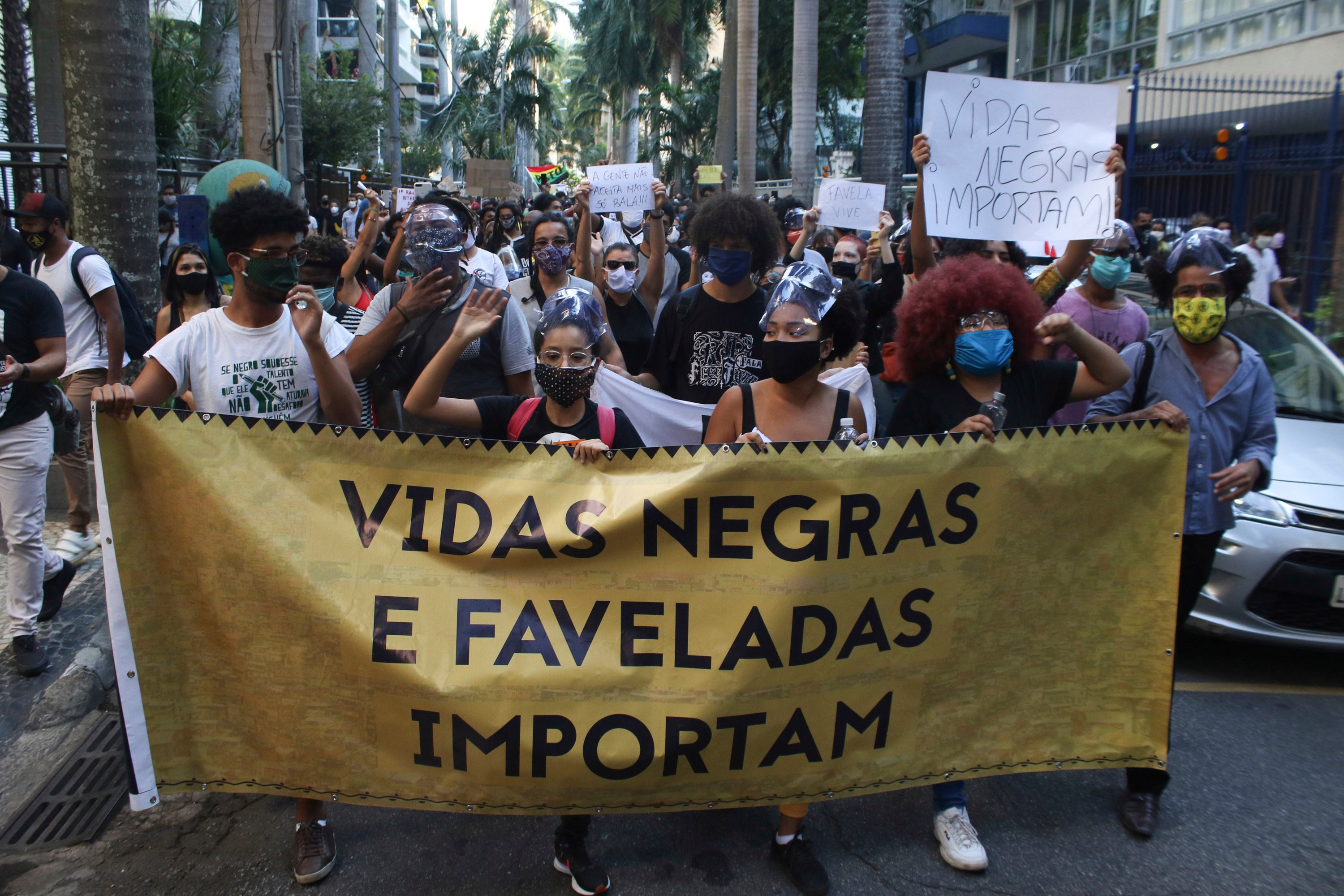 People protest against police killings in front of the Guanabara Palace, the residence of the Rio de Janeiro State Governor, on May 31, 2020. One sign reads “Black Lives Matter.”