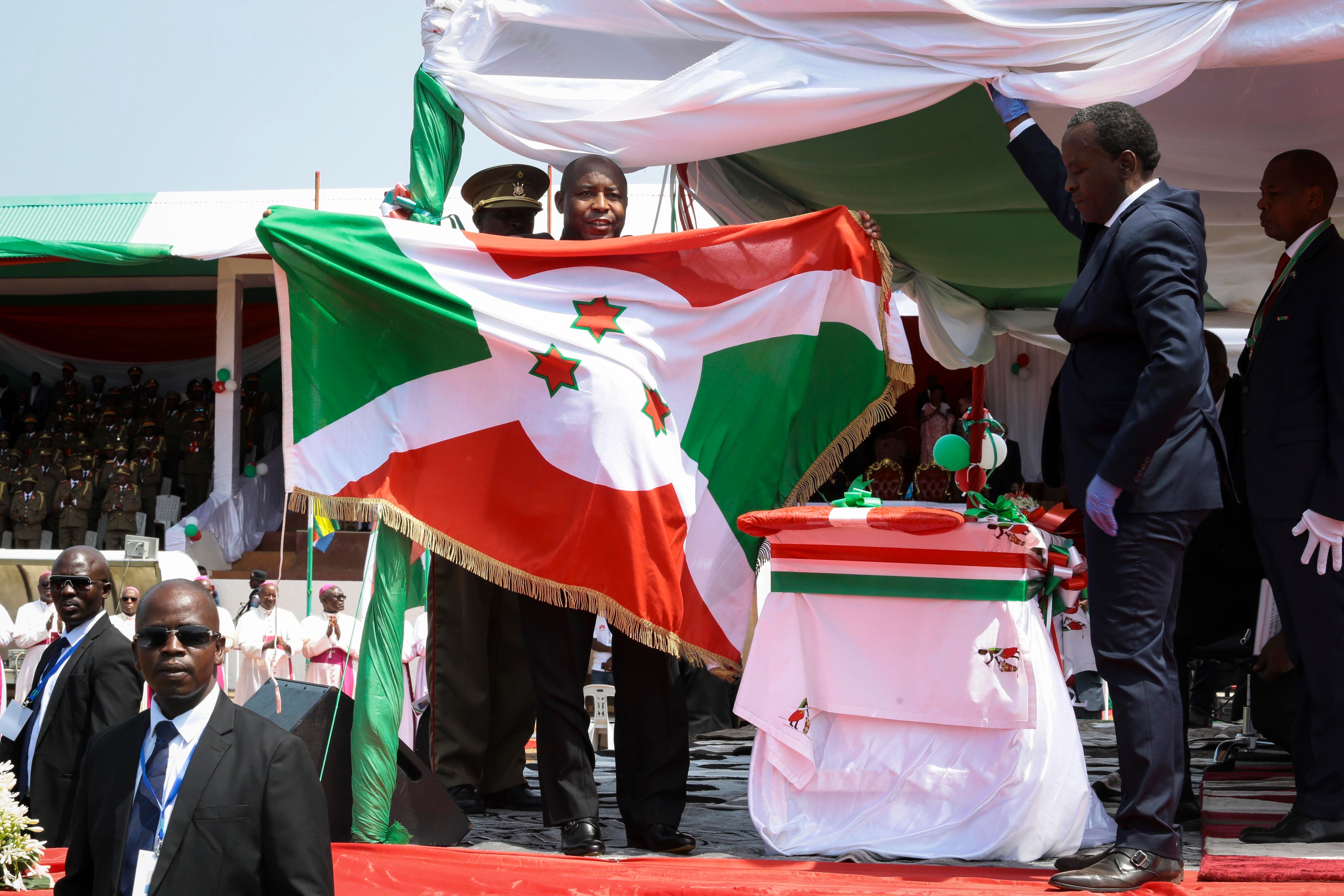 Le président burundais Evariste Ndayishimiye brandit le drapeau national après son investiture à Gitega, au Burundi, le 18 juin 2020.