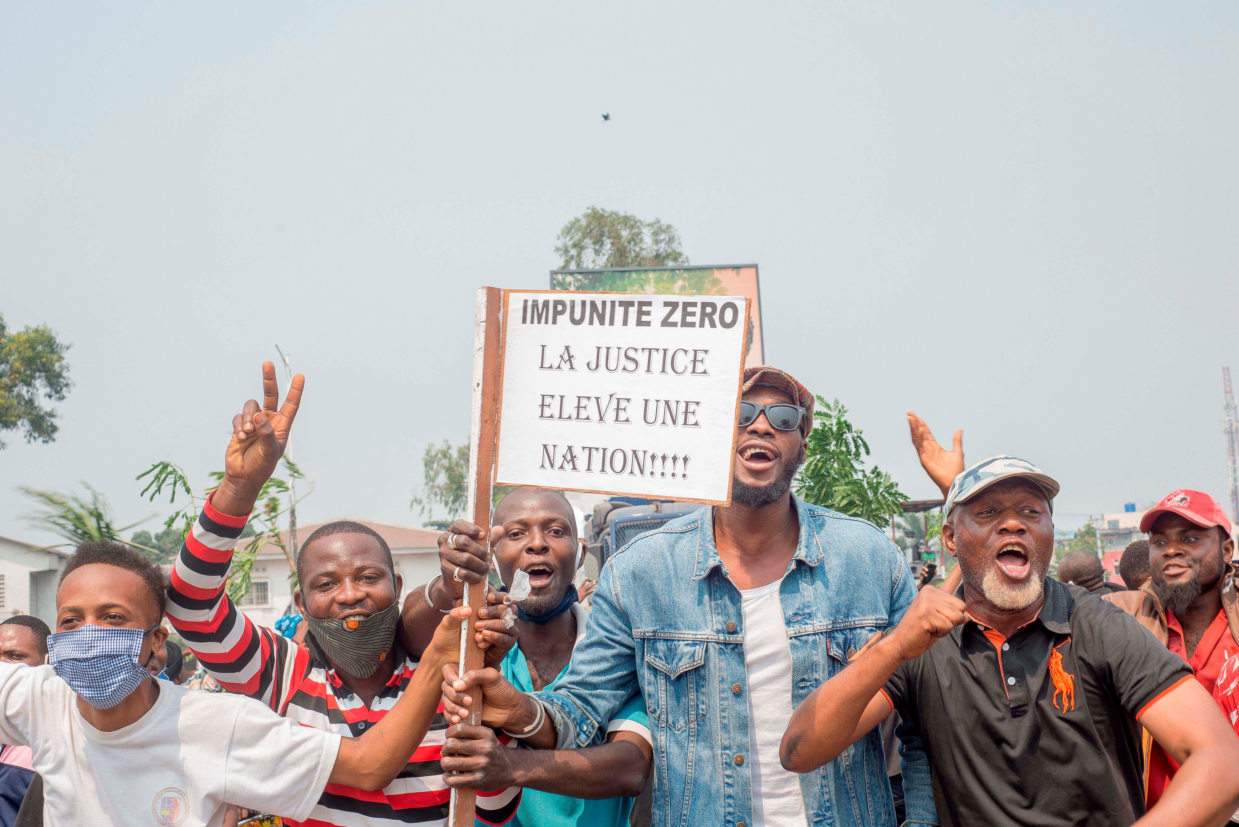 Protesters, including many motorbike-taxi drivers, demonstrate while holding placards for the second day around the Parliament in Kinshasa, June 24, 2020.