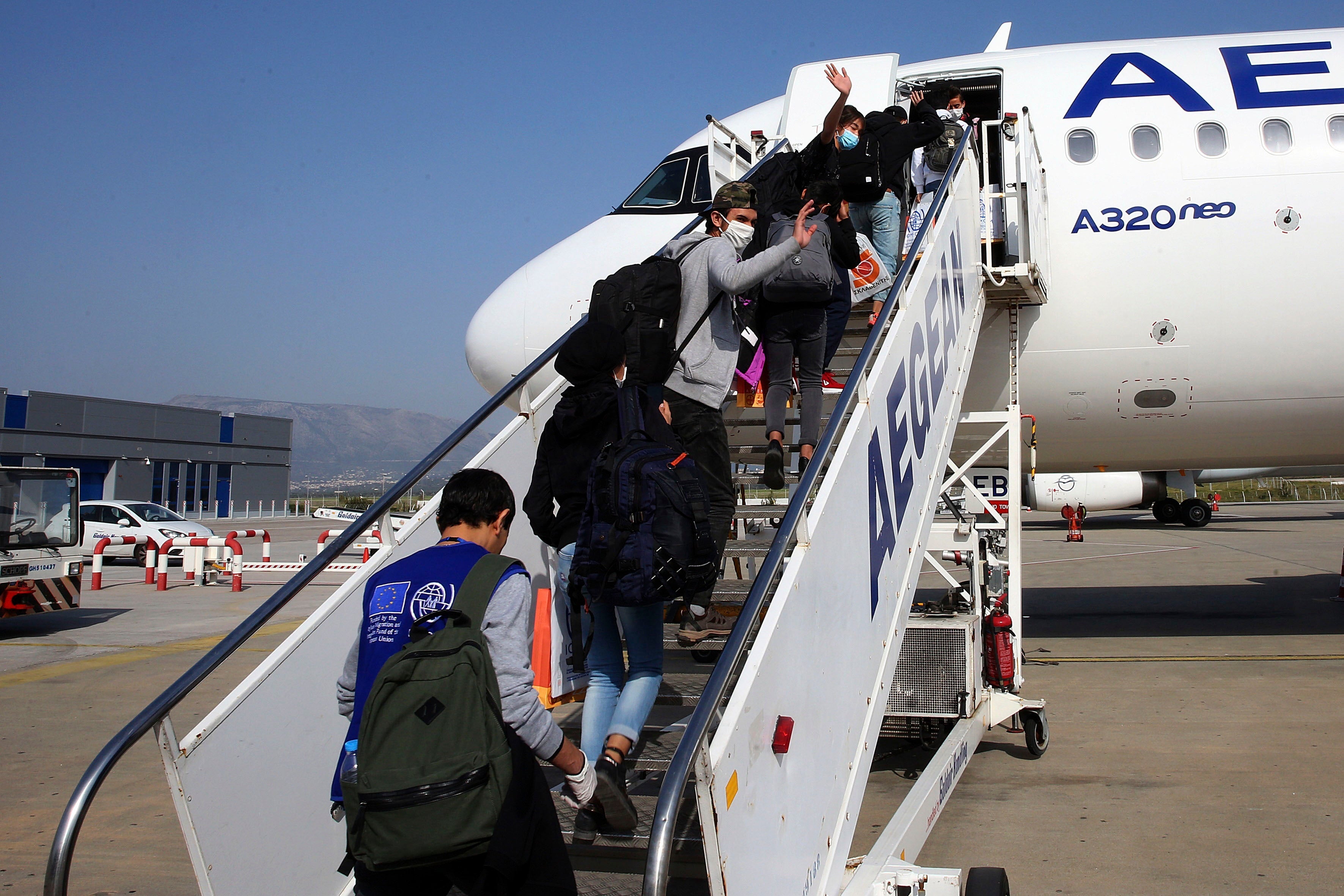 Unaccompanied children refugees from the overcrowded migrant camps on the north Aegean Sea islands, Greece, board a plane at the Eleftherios Venizelos International Airport in Athens to travel to Luxembourg, on Wednesday, April 15, 2020.