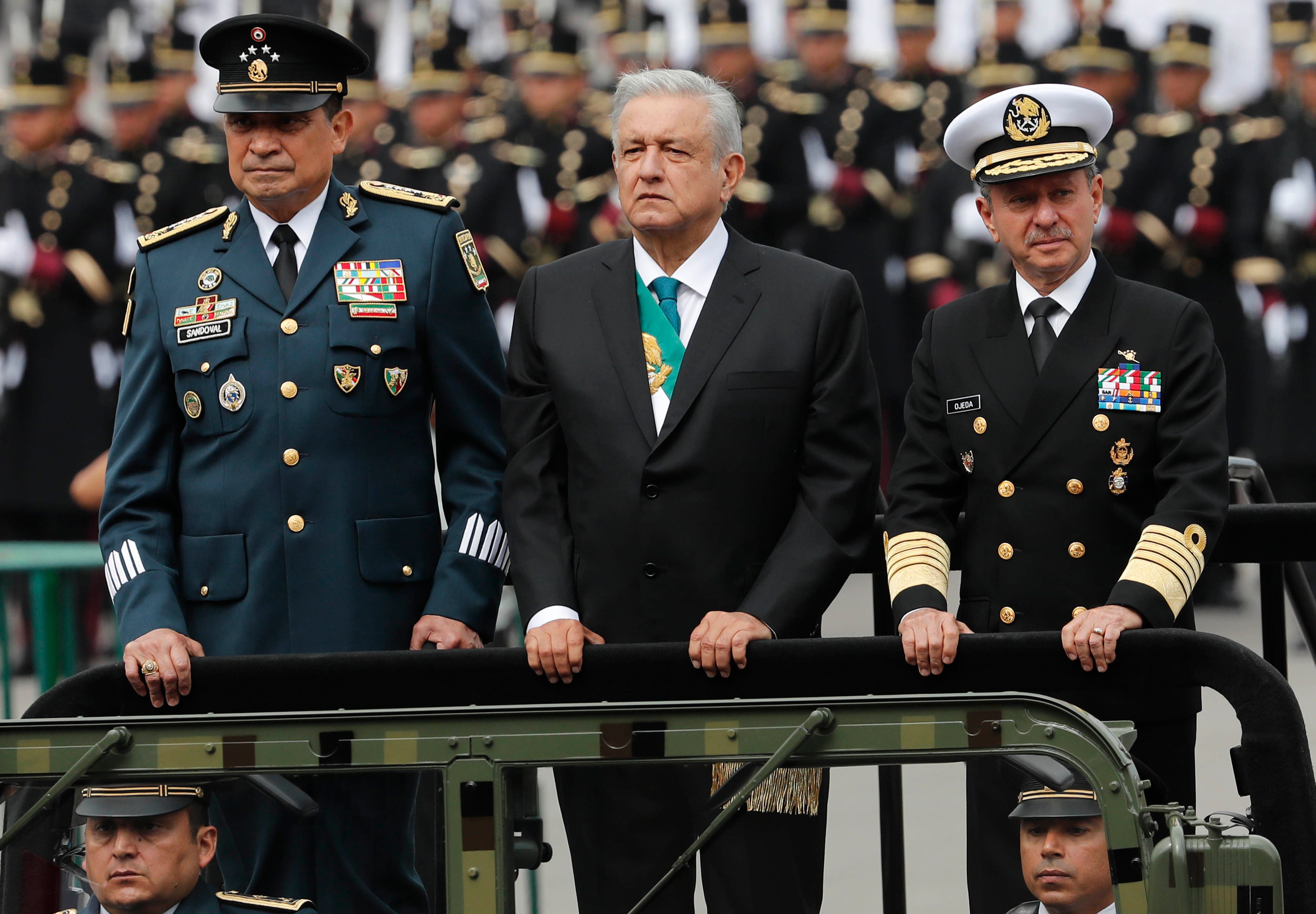 Mexican President Andres Manuel Lopez Obrador, center, stands with Secretary of Defense Luis Crescencio Sandoval, left, and Secretary of the Navy, Vidal Francisco Soberon, in an open military vehicle during the Independence Day military parade in the capital's main plaza, the Zocalo, in Mexico City. 