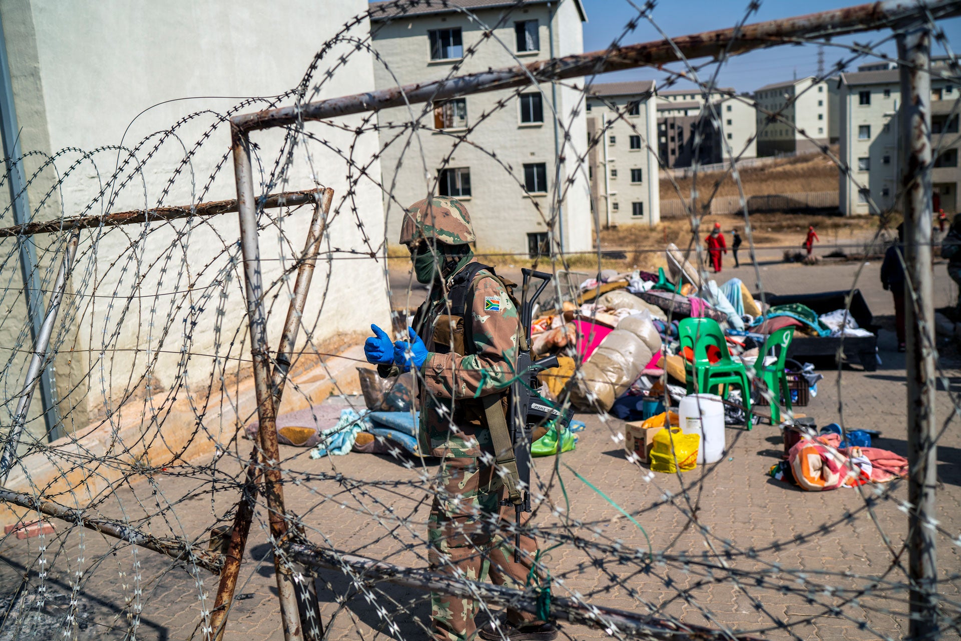 A South Africa soldier guards the entrance of a housing development while flats are being emptied in Johannesburg, South Africa, Wednesday Aug. 12, 2020.