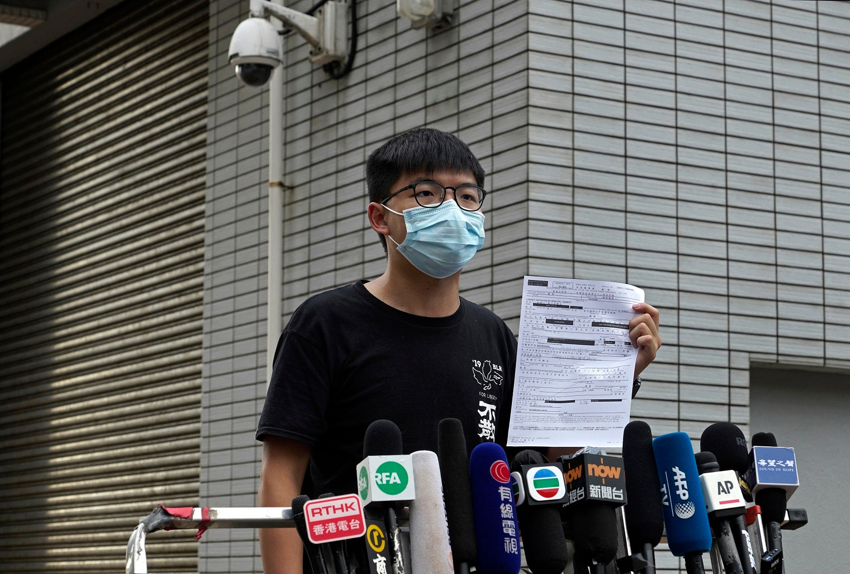 Hong Kong pro-democracy activist Joshua Wong displays a bail paper outside Central Police Station in Hong Kong, Thursday, Sept. 24, 2020. 