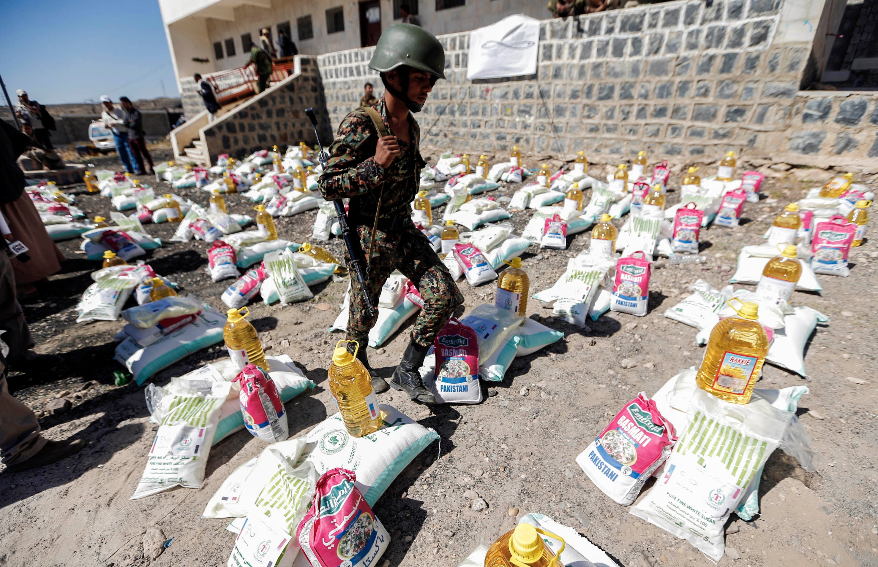A uniformed soldier walks through aid packages