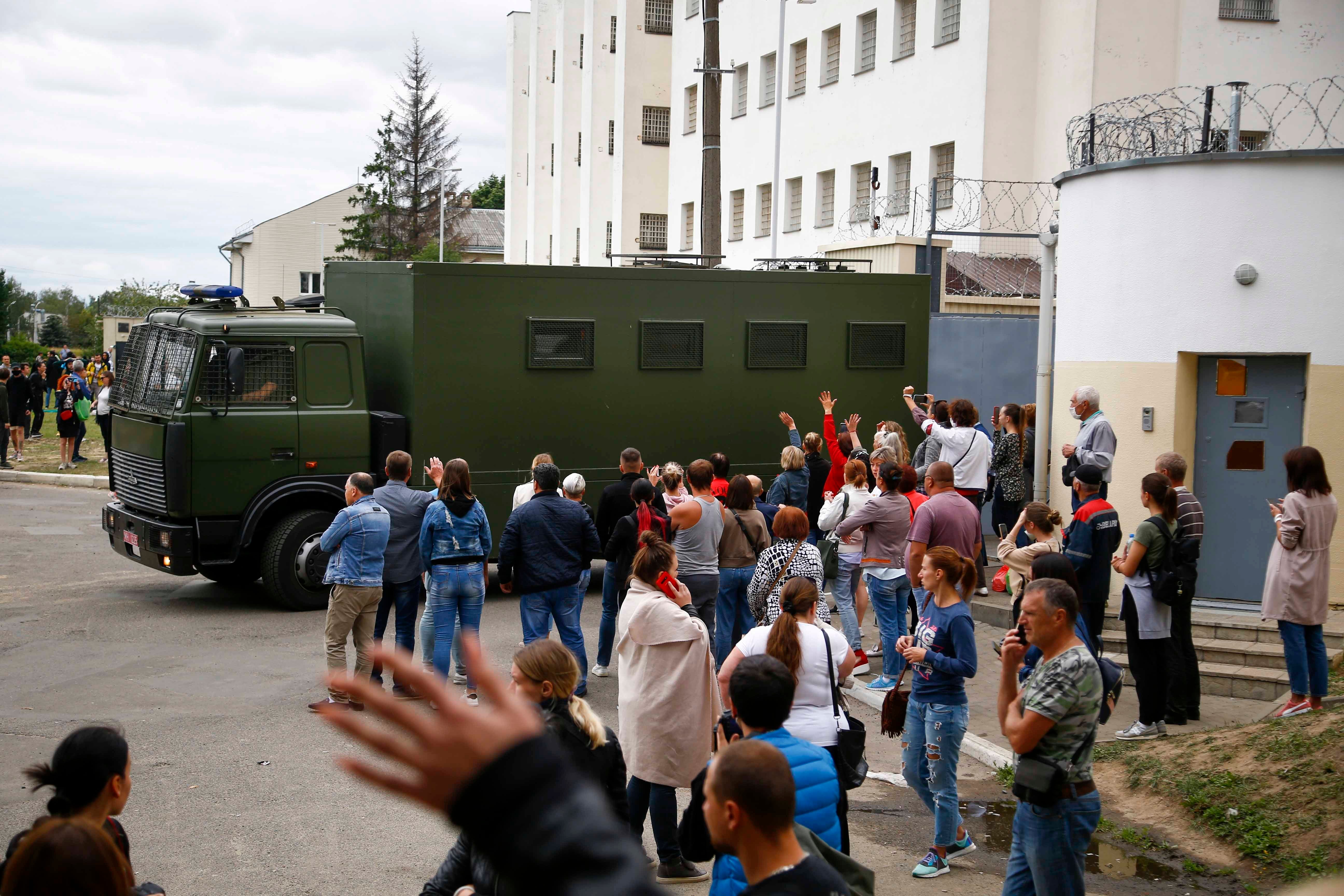 Friends and relatives of those detained during a mass rally following the disputed results of the presidential election gather at a detention center as a police bus drives out of the gate in Minsk, Belarus, Wednesday, Aug. 12, 2020.  