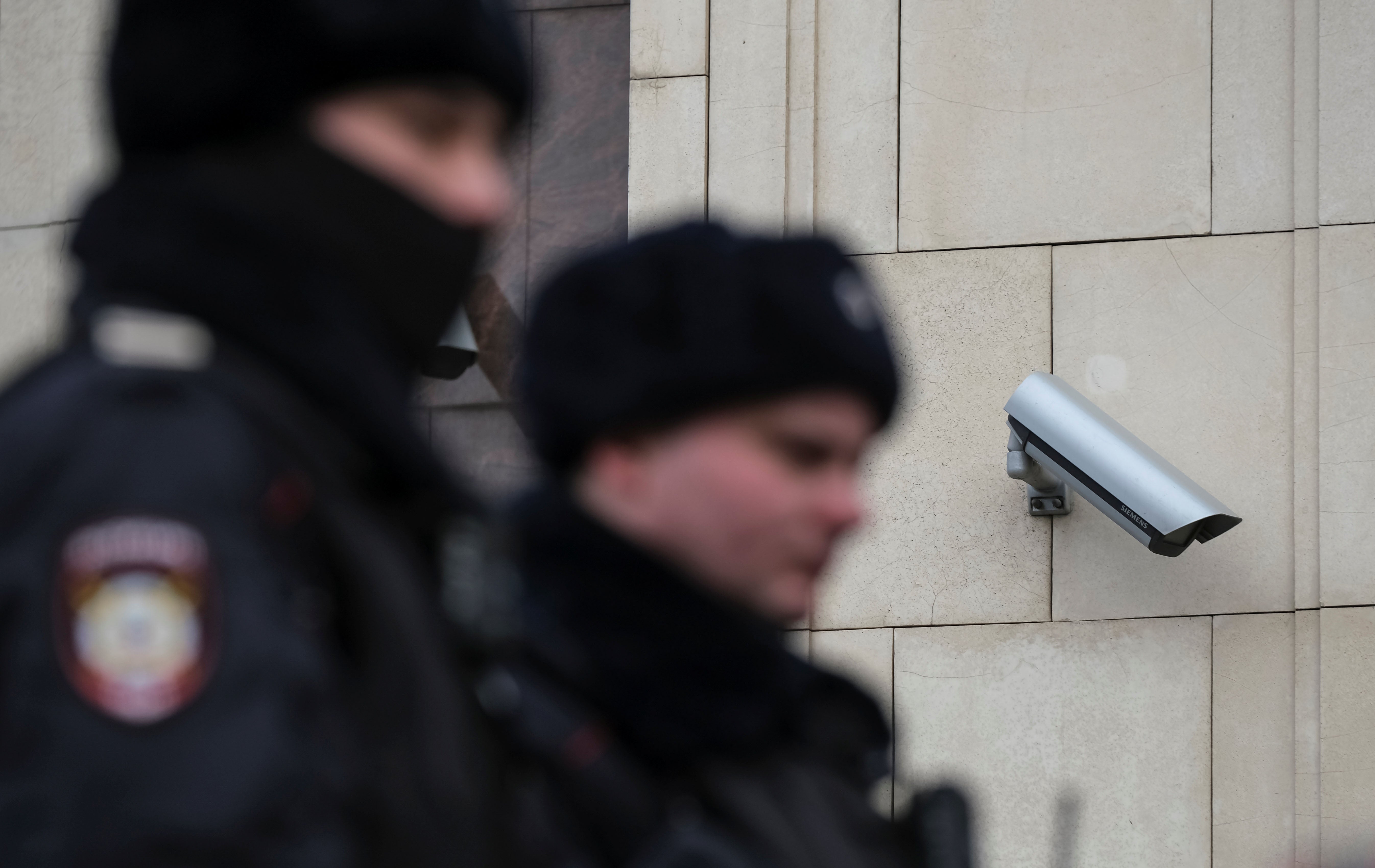 Police officers walk past a surveillance camera in central Moscow, Russia January 26, 2020.