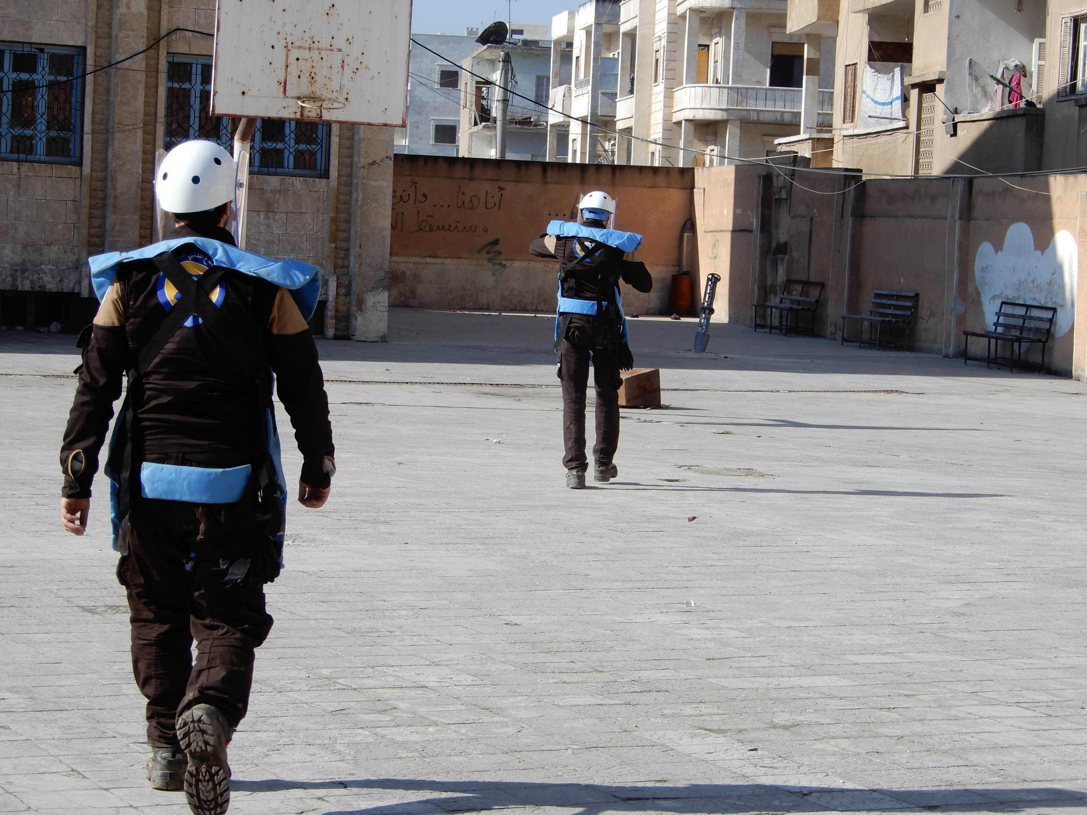 Two men in helmets in a schoolyard