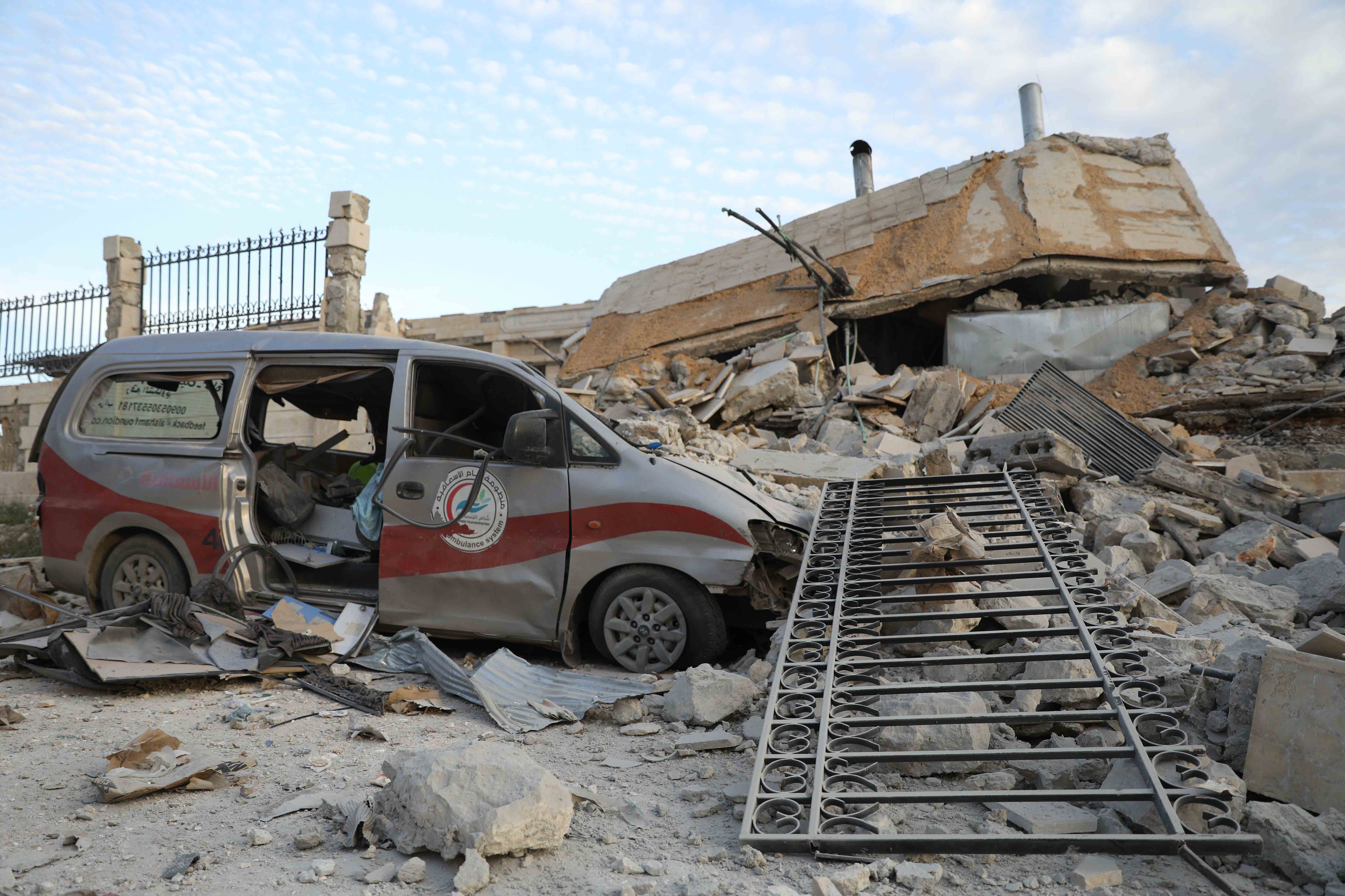 A destroyed van surrounded by building debris