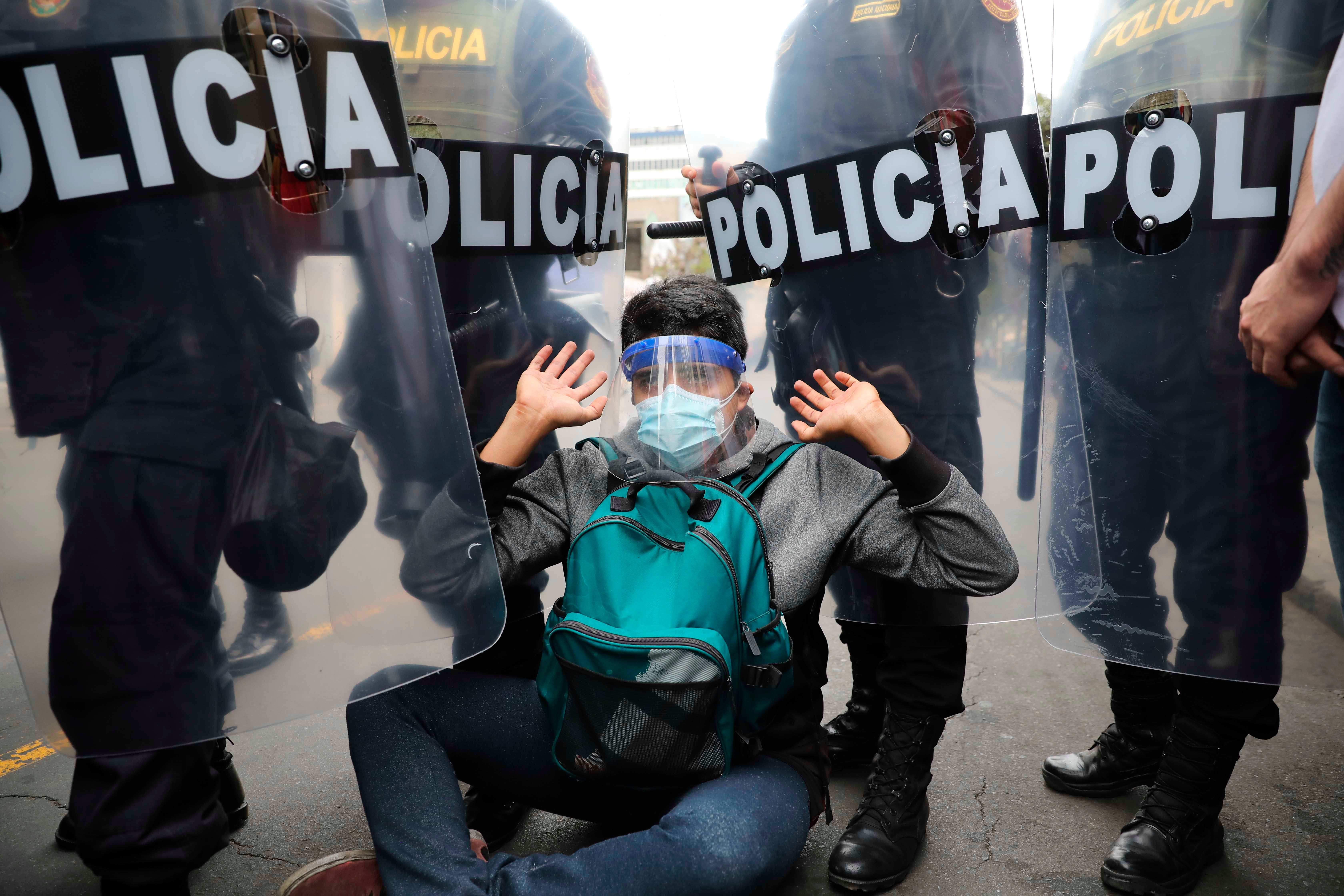 Police surround a protester in Lima, Peru, Tuesday, Nov. 10, 2020.