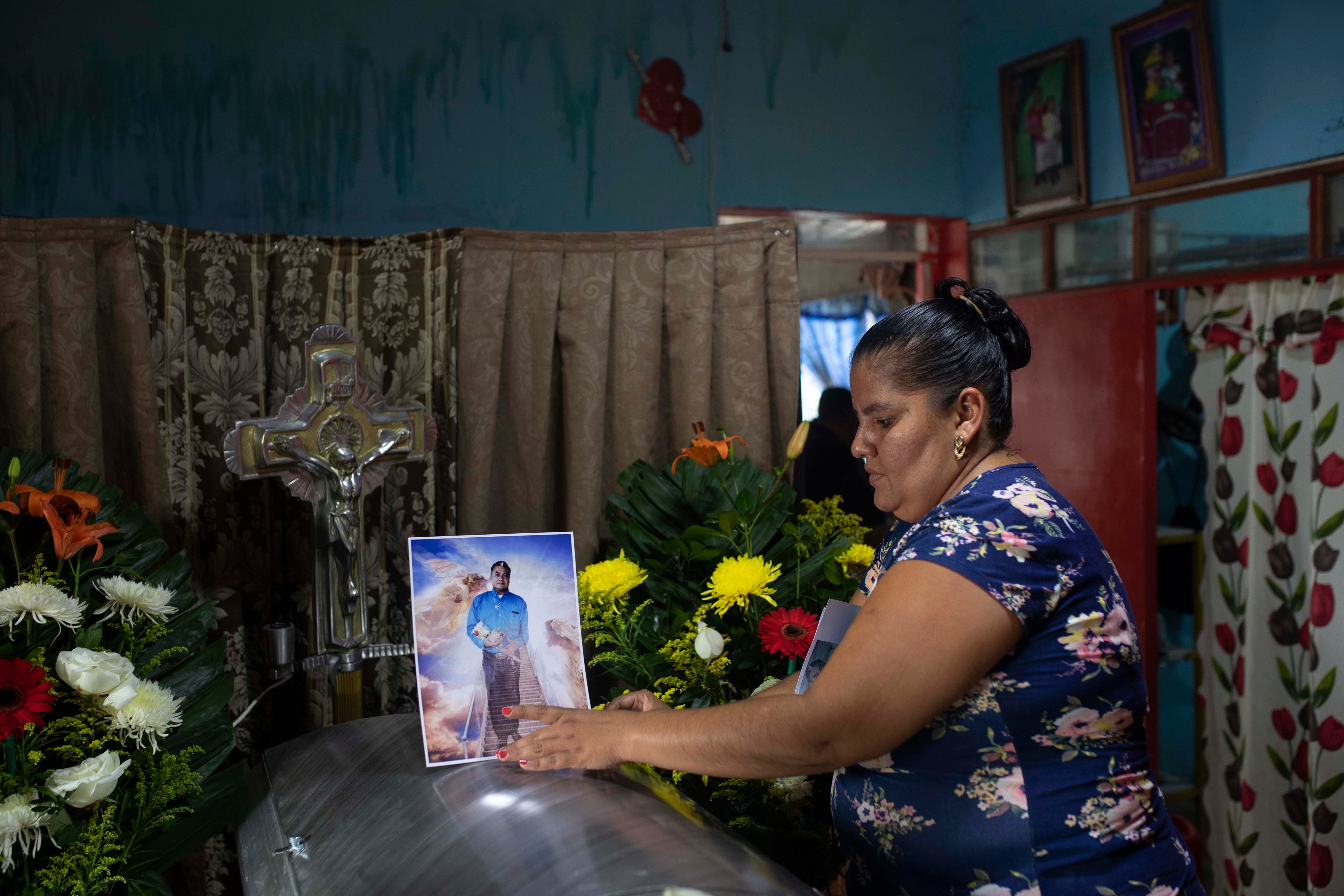 A woman places a photo of slain journalist Julio Valdivia on his casket during a wake inside his home in Tezonapa, Mexico, on September 10, 2020.