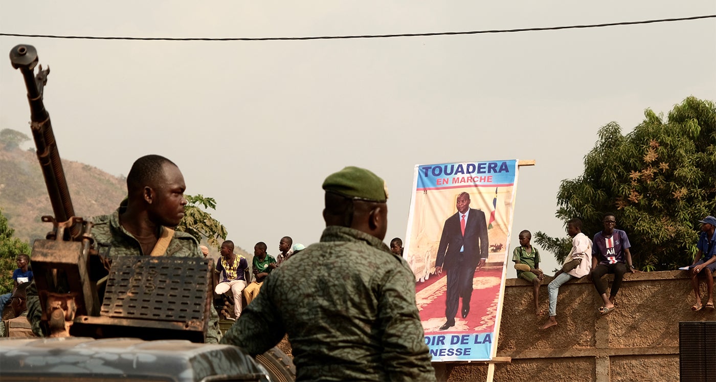 Presidential guards stand guard in Bangui, on December 12, 2020, during the opening campaign rally for incumbent president Faustin-Archange Touadéra, seen in the poster, a candidate in the December 2020 elections.