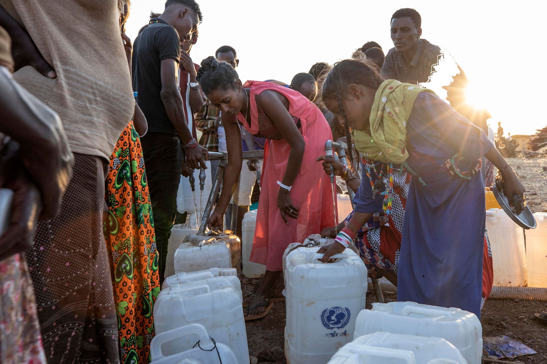 Women pour water into containers at Um Raquba refugee camp in al-Gadaref state, eastern Sudan, November 27, 2020. 