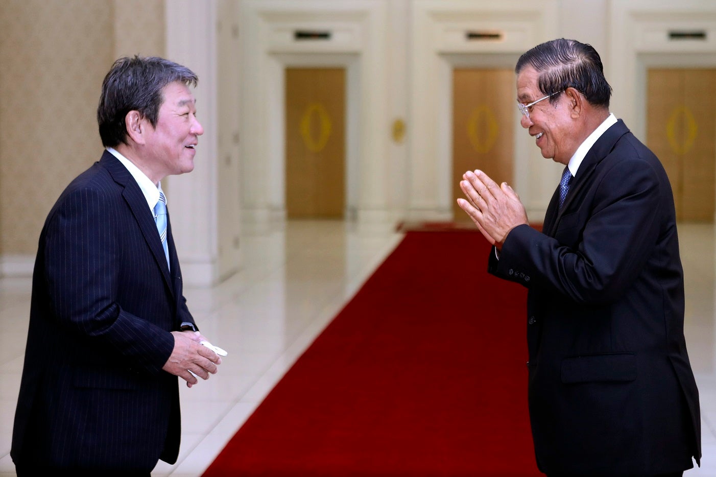 Cambodian Prime Minister Hun Sen, right, greets with Japanese Foreign Minister Toshimitsu Motegi, left, before a meeting at the Peace Palace, in Phnom Penh, Cambodia on Saturday, August 22, 2020. 