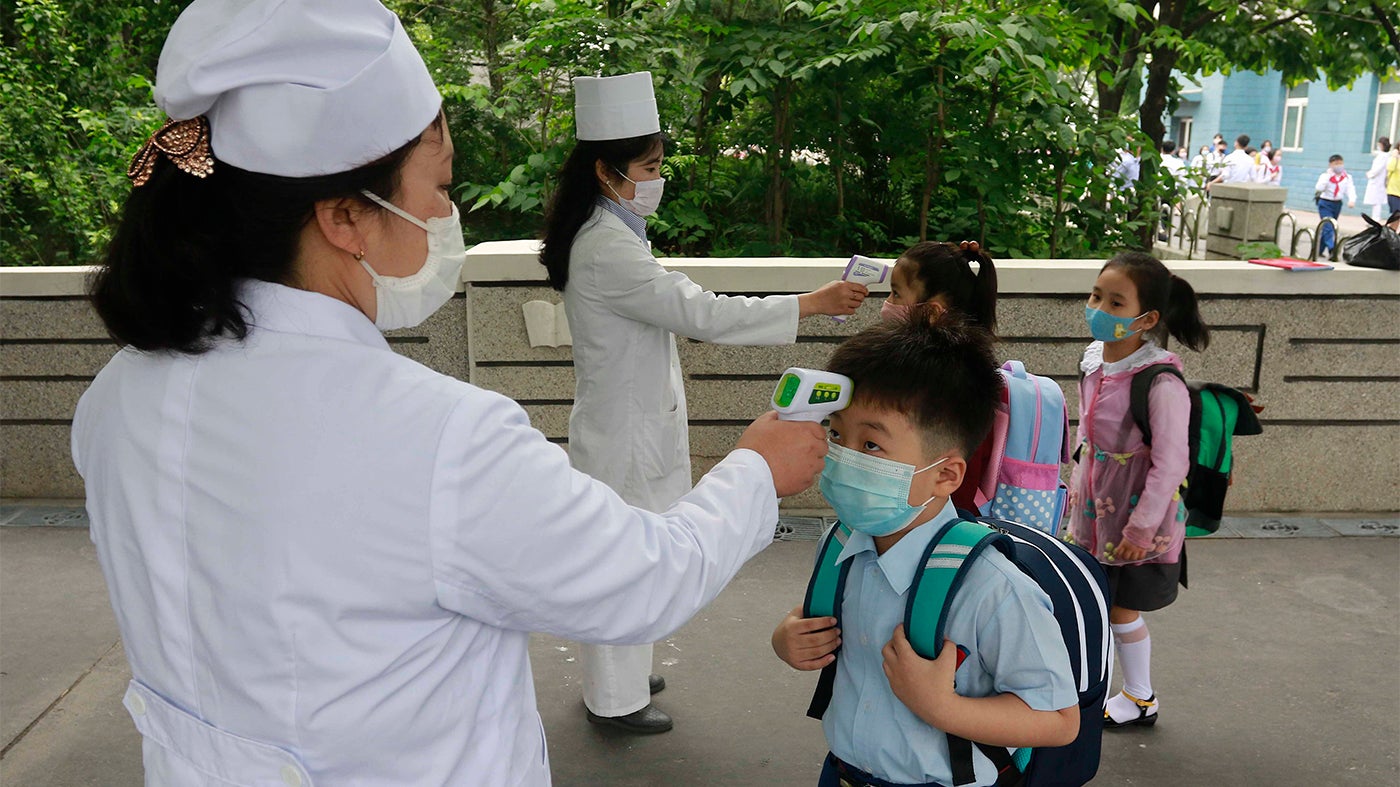 أطفال في "ابتدائية كيم سونغ جو" يصطفّون ليتم قياس حرارتهم قبل دخول المدرسة في بيونغيانغ، كوريا الشمالية. 