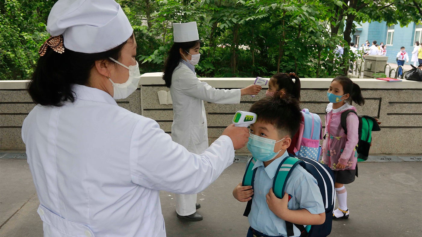 평양의 김성주초등학교 학생들이 학교에 들어가기 전에 체온을 재고 있다.  